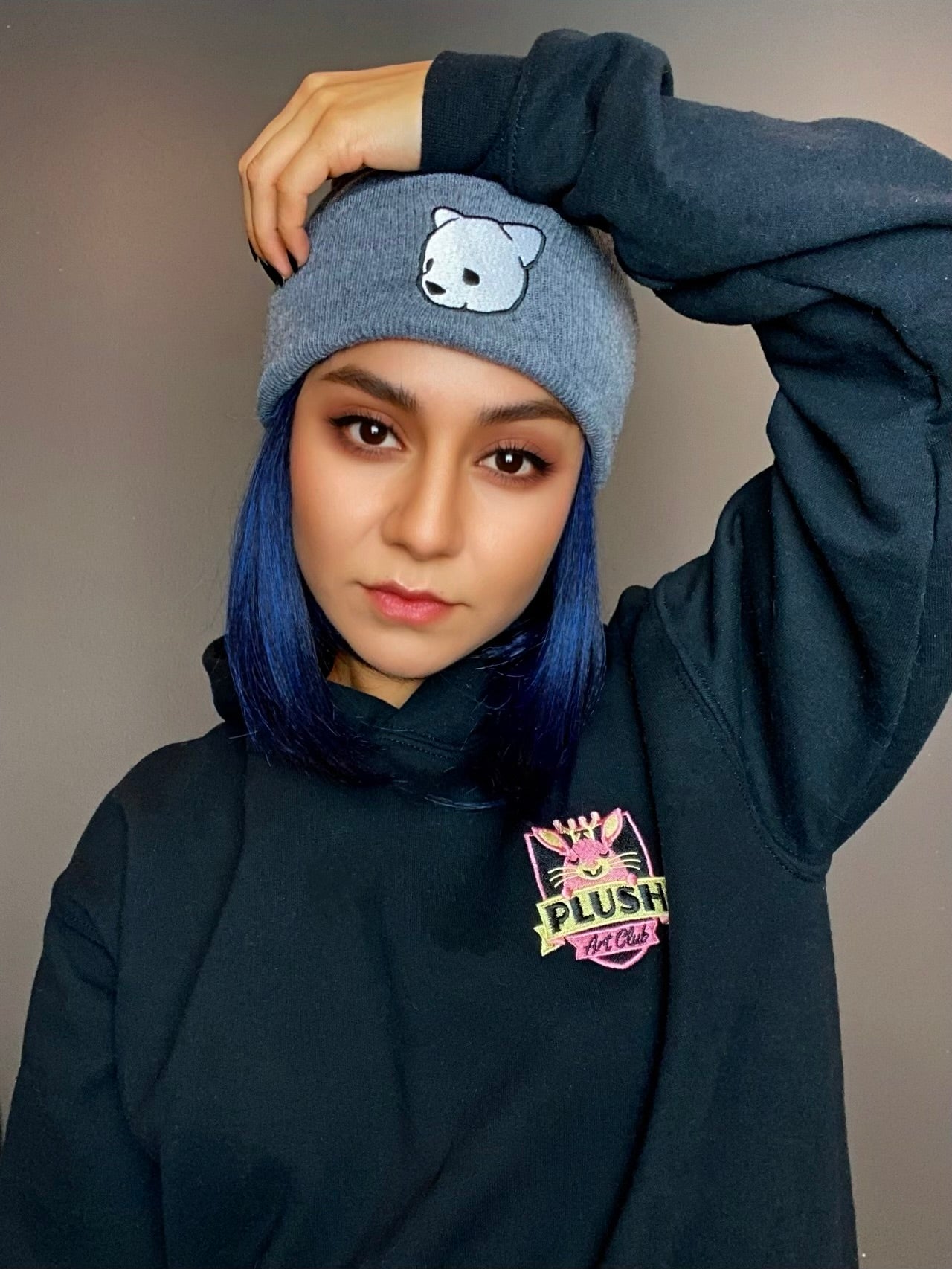 Gray beanie featuring Luke Chueh's bear head. Published by Plush Art Club. Modeled by Alejandra Moreno.